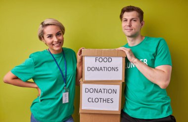 Mutlu genç gönüllüler hayır kurumları için giysi ve yiyecek bağışlıyorlar.