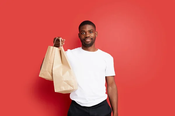 Giovane corriere africano uomo tenere sacchetti di carta con il cibo — Foto Stock