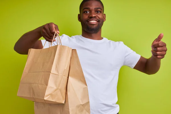 Portret van tevreden koerier man met levering voedsel in papieren zakken — Stockfoto