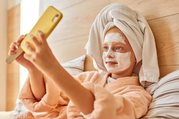 Aantrekkelijk meisje in masker nemen foto van zichzelf — Stockfoto