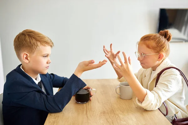 Lindos niños peleando en casa sentado en la mesa —  Fotos de Stock