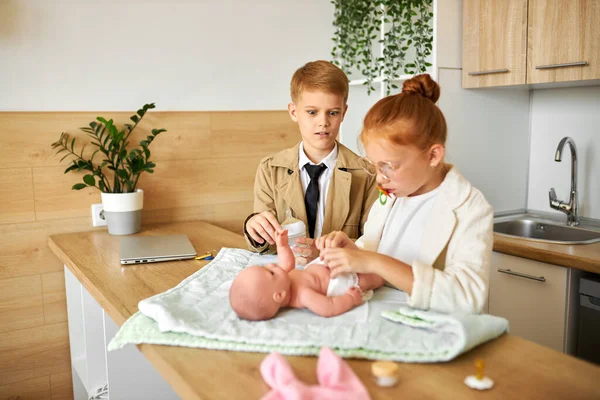 Young parents, children take care of baby — Stock Photo, Image