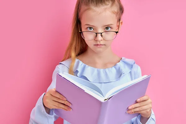 Adorable caucasien fille dans lunettes lire un livre isolé — Photo