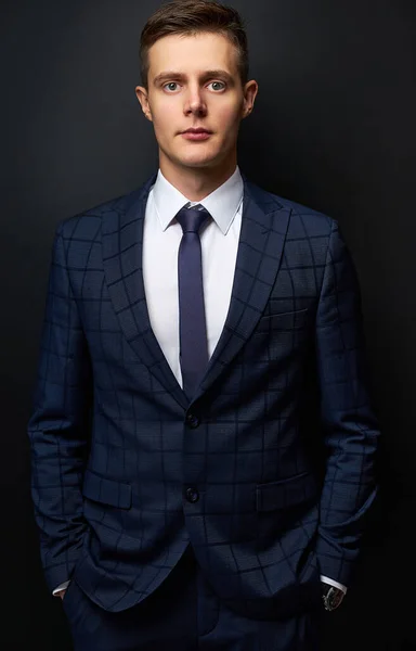 confident trendy guy in formal suit posing isolated on black background