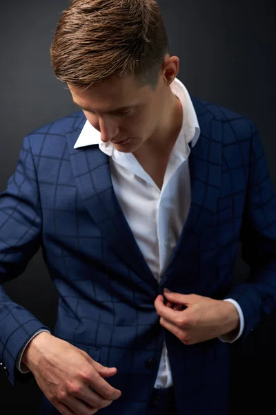 Rich young male in classic formal suit or tux fixing button on jacket — Stock Photo, Image