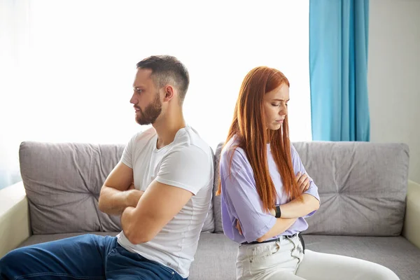 Young caucasian couple offended on each other, sit turning away from each other — Stock Photo, Image