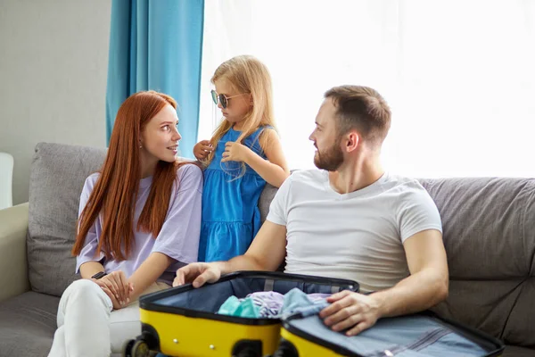 Familia caucásica con niña discutir qué llevar con ellos para las vacaciones, vacaciones — Foto de Stock