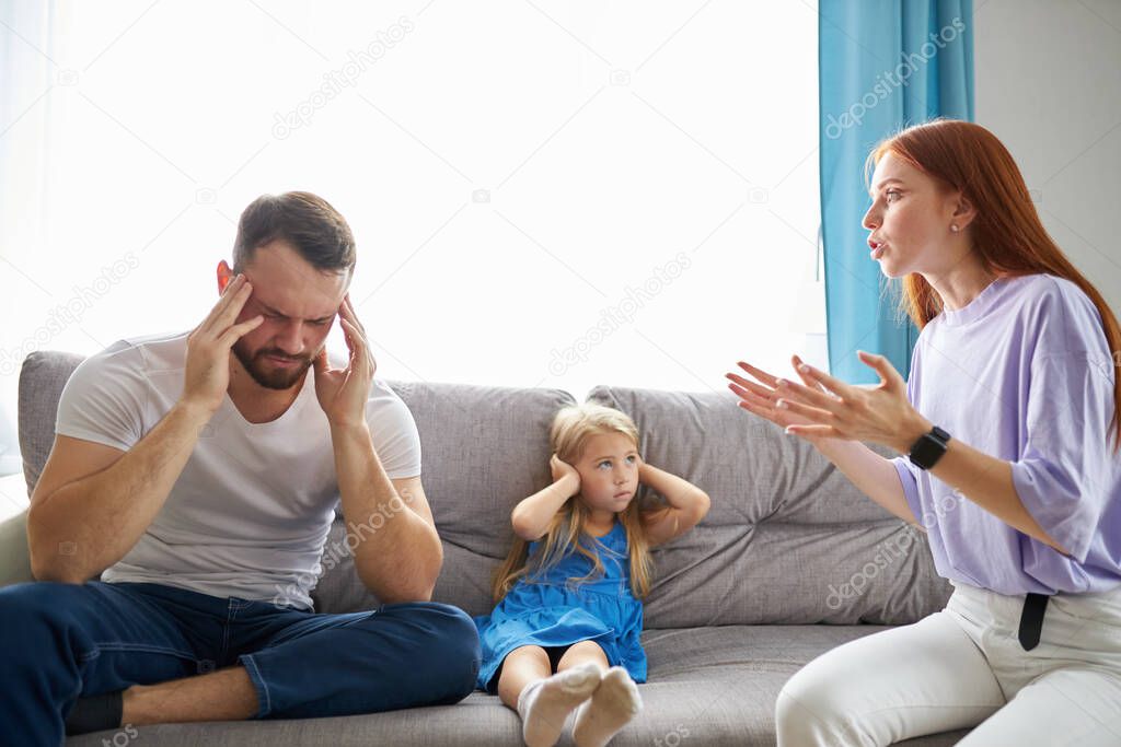 child girl is suffering from quarrels between parents in the family at home
