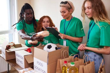 Çeşitli gönüllüler bağış kutusunda insani yardım topluyorlar.