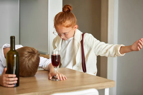 Gyermekalkoholizmus. A kisfiú otthon iszik alkoholt. — Stock Fotó