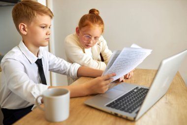 Güzel beyaz çift çocukları dizüstü bilgisayarda birlikte çalışıyorlar.