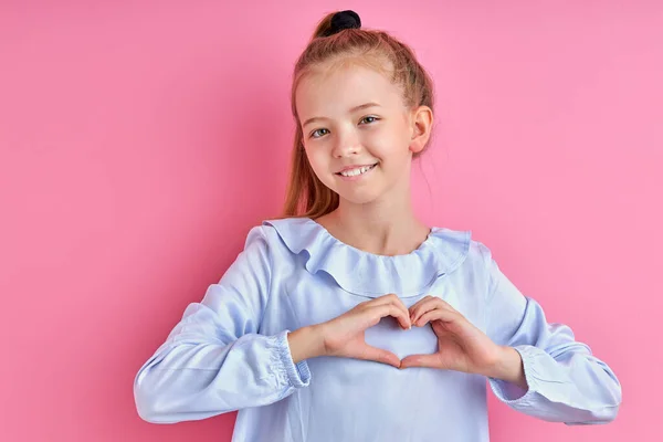 Boldog kaukázusi lány mutatja szív készült kéz a kamera — Stock Fotó