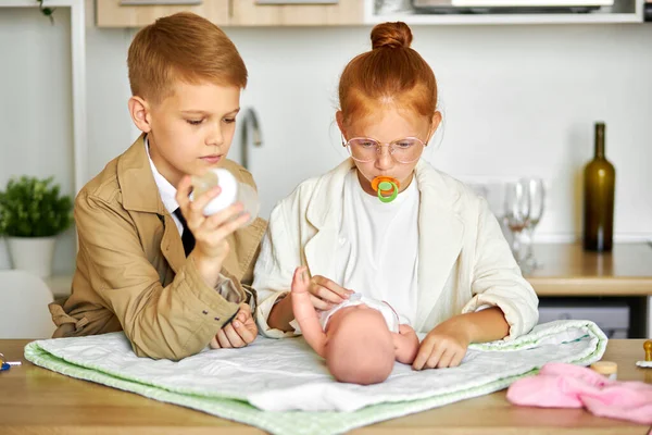 Padres jóvenes, los niños cuidan del bebé — Foto de Stock