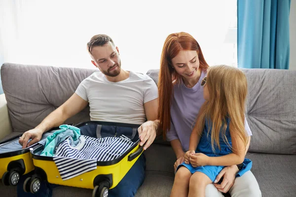 Familia caucásica con niña discutir qué llevar con ellos para las vacaciones, vacaciones — Foto de Stock