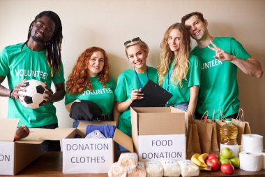 Mutlu genç gönüllüler hayır kurumları için giysi ve yiyecek bağışlıyorlar.