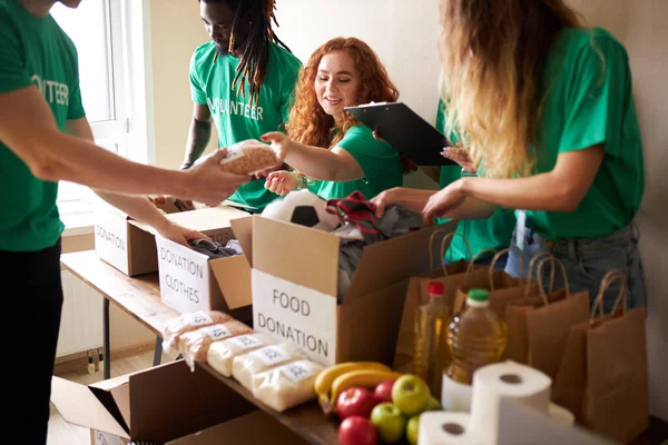 Jóvenes voluntarios entusiastas con donaciones para los pobres — Foto de Stock