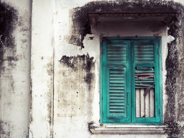 Eski yeşil ahşap pencere ve binanın beyaz duvar.