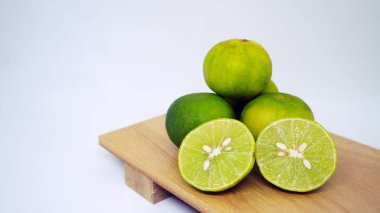 Beyaz arka plan üzerinde izole ahşap tepsi üzerinde taze limon.