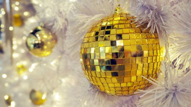 Yansıtılmış bir disko topu ve beyaz bir arka plan üzerinde Noel süsleri.