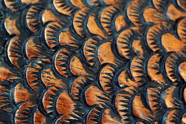 cutter carves the fish from the wood. wood carving closeup. Fish scale.