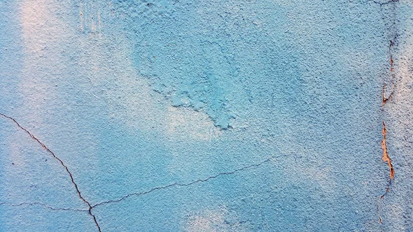 Old cracked wall background, dirty grunge texture. Cracks in the walls blue