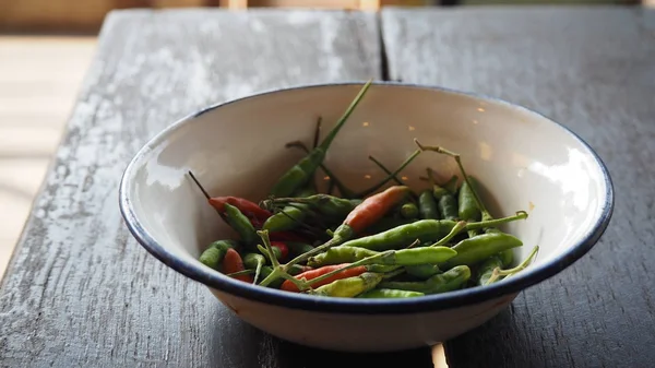 Taze kırmızı ve yeşil biber ve kıyılmış taze kırmızı ve yeşil biber ahşap kesme blok üzerinde. Gine biber; kuş biber; kuş-chil 