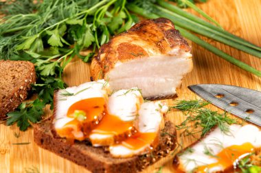 Tütsülenmiş et sebze ve sosla birlikte masada yatıyor.