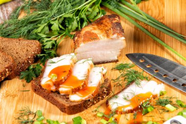 Tütsülenmiş et sebze ve sosla birlikte masada yatıyor.