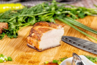 Tütsülenmiş et sebze ve sosla birlikte masada yatıyor.