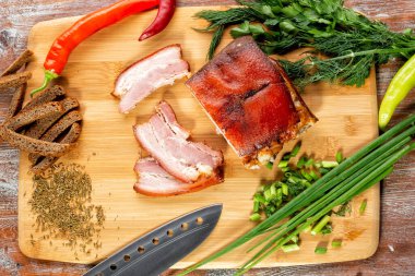 Tütsülenmiş et sebze ve sosla birlikte masada yatıyor.