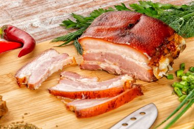 Tütsülenmiş et sebze ve sosla birlikte masada yatıyor.