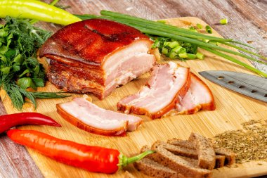 Tütsülenmiş et sebze ve sosla birlikte masada yatıyor.