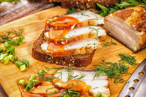 Tütsülenmiş et sebze ve sosla birlikte masada yatıyor.