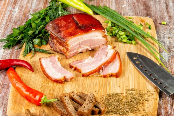 Tütsülenmiş et sebze ve sosla birlikte masada yatıyor.