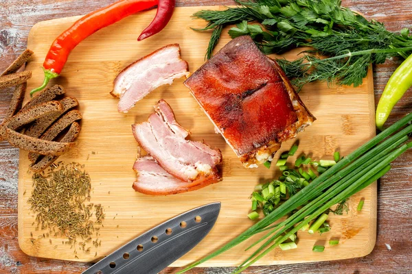 Tütsülenmiş et sebze ve sosla birlikte masada yatıyor.