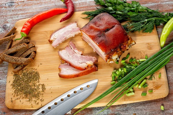 Tütsülenmiş et sebze ve sosla birlikte masada yatıyor.