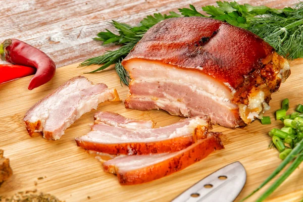 Tütsülenmiş et sebze ve sosla birlikte masada yatıyor.