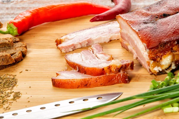 Tütsülenmiş et sebze ve sosla birlikte masada yatıyor.