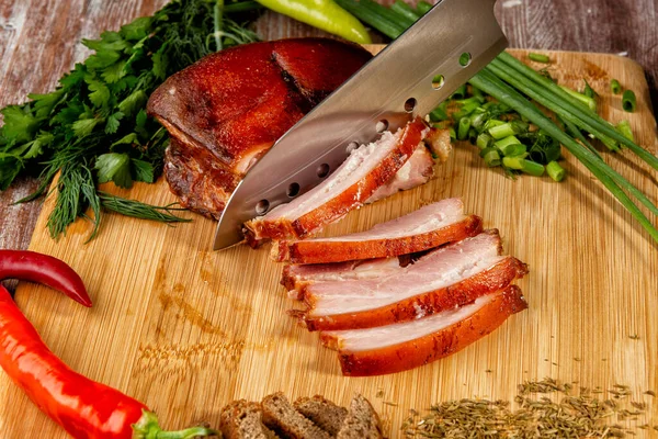 Tütsülenmiş et sebze ve sosla birlikte masada yatıyor.