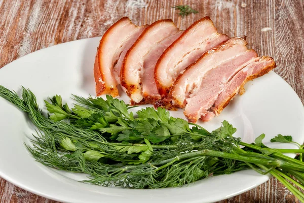 Smoked meat lies on the table with herbs and sauce — Stock Photo, Image