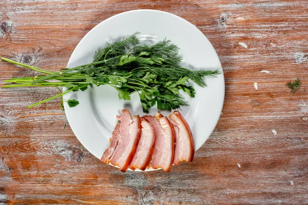 Carne ahumada se encuentra en la mesa con hierbas y salsa — Foto de Stock