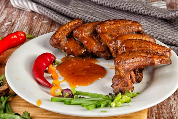 Összetétel füstölt csirkeszárnyakkal az asztalon — Stock Fotó