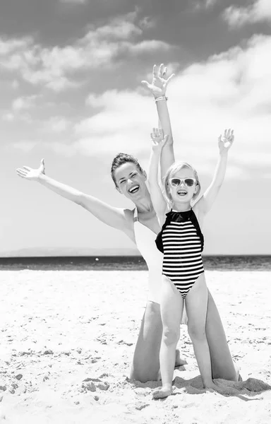 白い砂の上の家族の楽しみです 海岸歓喜のビーチウェアで幸せな若い母と娘 — ストック写真