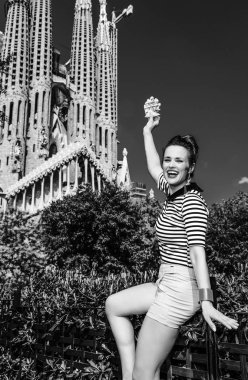 Barcelona - 10 Temmuz 2017: genç turist kadın şort ve Sagrada Familia için Barselona, İspanya, gözleme gösterilen önünde çizgili gömlek