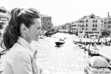 Saçını o mesafe içine kapalı göründüğü bir at kuyruğu, bu zarif turist gülümsüyor süpürüldü. Arka plan, Venedik'in zengin renk ve onun çok sayıda kanal birini.