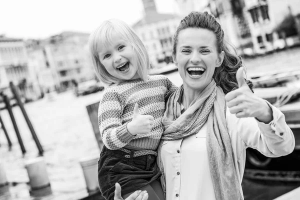 Lykkelig Mor Baby Pige Stående Dæmning Venice Kursiv Viser Tommelfingre - Stock-foto