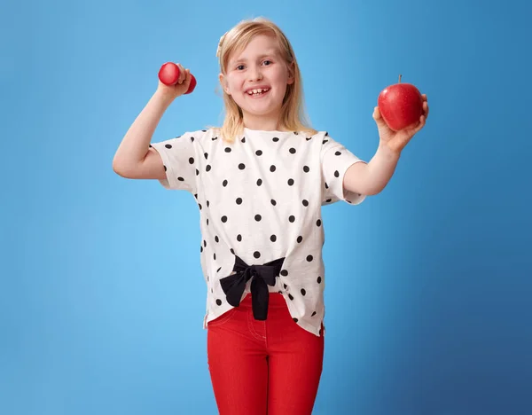 Sonriente Chica Moderna Pantalones Rojos Mostrando Bíceps Una Manzana — Foto de Stock