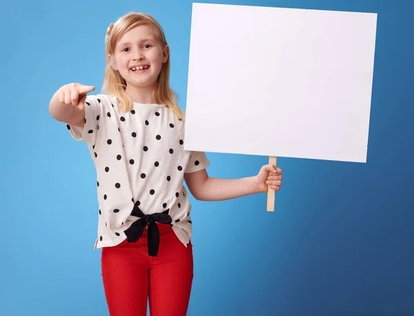 Smilende Moderne Barn Røde Bukser Med Blank Plakat Peger Kameraet - Stock-foto