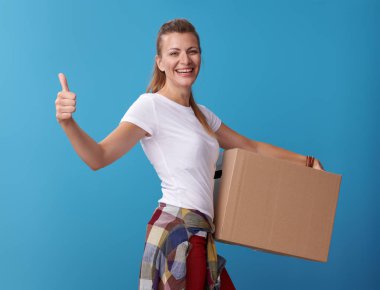 etkin tutan bir karton kutu mavi zemin üzerine beyaz gömlek gülümseyen