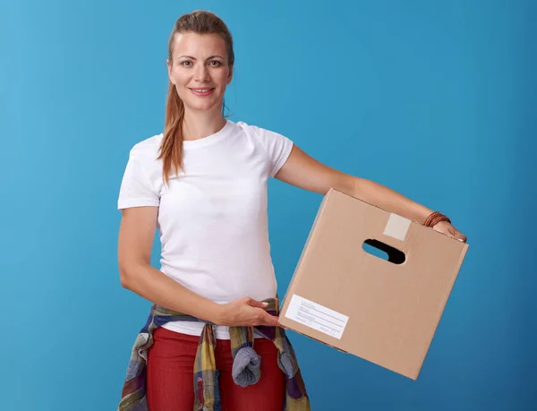 白いシャツが青の背景に段ボール箱を抱えての幸せな現代の女性の肖像画 — ストック写真